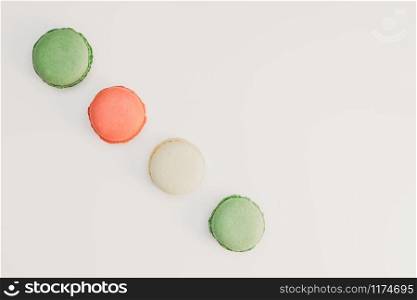 Assorted sweet pastel color macaroons on white background top view. Dessert macaron flat lay.
