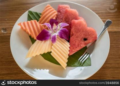 assorted tropical fruits set on white dish