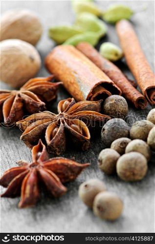Assorted whole spices close up on wooden background