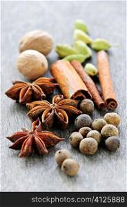 Assorted whole spices close up on wooden background