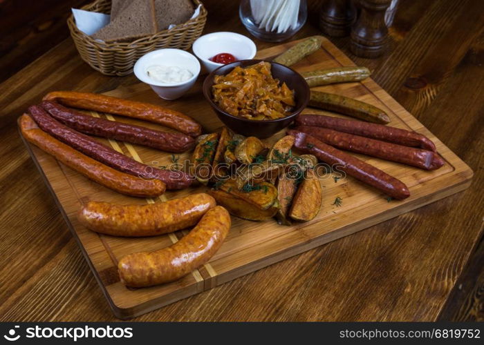 assortment hot sausages serving on wooden board in restaurant