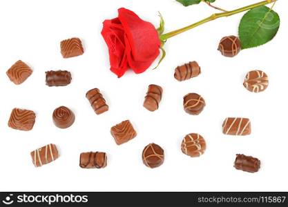 Assortment of chocolate candies and red rose isolated on white background. Flat lay, top view. Free space for text.