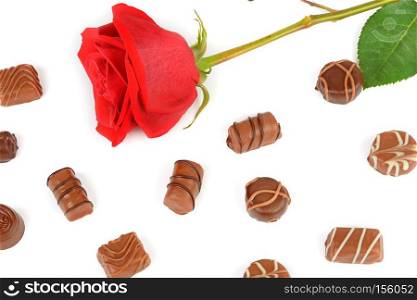 Assortment of chocolate candies and red rose isolated on white background. Flat lay, top view.