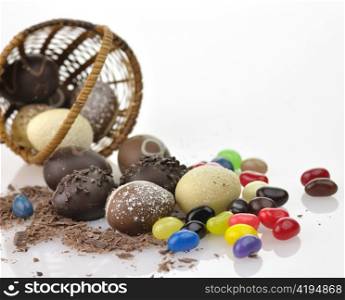 assortment of chocolate eggs , candies and a basket, close up