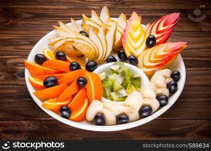 Assortment of chopped fruits on wooden table