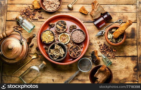 Assortment of dry healthy herbs on an old wooden table in herbal medicine. Natural medicine. Dry healthy herbs in natural herbal medicine