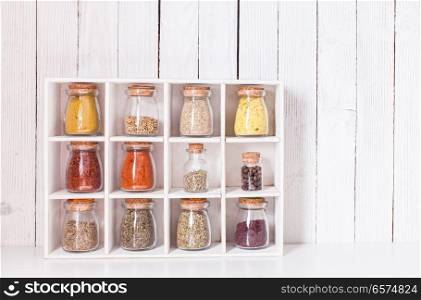 Assortment of dry spices in vintage glass bottles in wooden box. Still life with spices