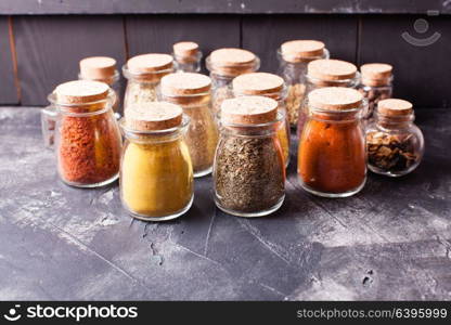 Assortment of dry spices in vintage glass bottles on white background. Still life with spices