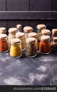 Assortment of dry spices in vintage glass bottles on white background. Still life with spices