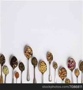 Assortment of dry tea in vintage spoons. Tea types backgound, flat lay, space for your text or logo