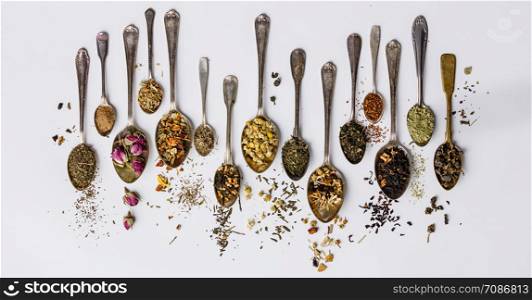 Assortment of dry tea in vintage spoons. Tea types backgound, flat lay