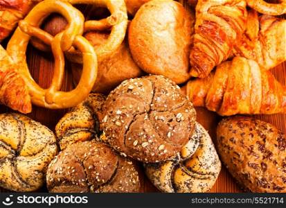 assortment of fresh bread and pastry on wooden table