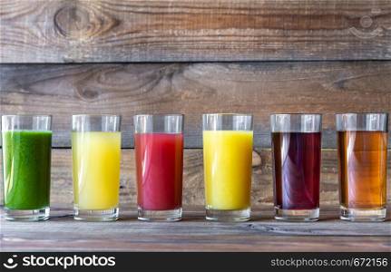 Assortment of fruit juices on the wooden background