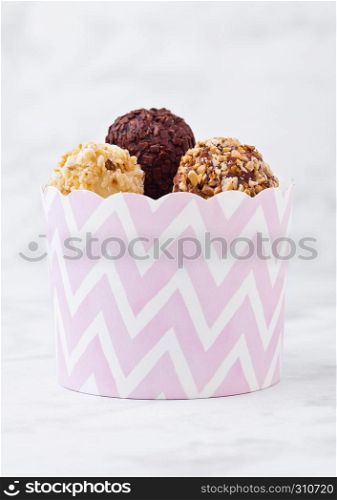 Assortment of luxury white and dark chocolate candies variety in pink paper party container
