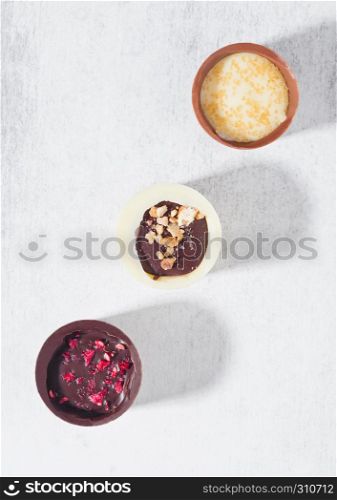 Assortment of luxury white and dark chocolate candies variety on white background with hard shadows