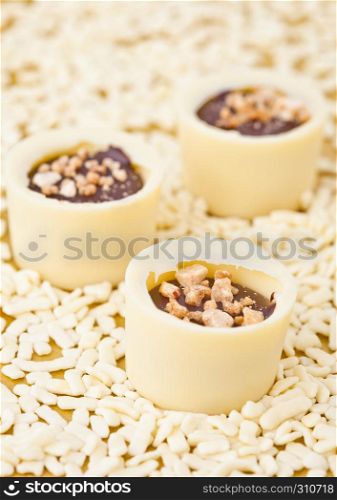 Assortment of luxury white chocolate candies variety on a golden background with white chocolate pieces