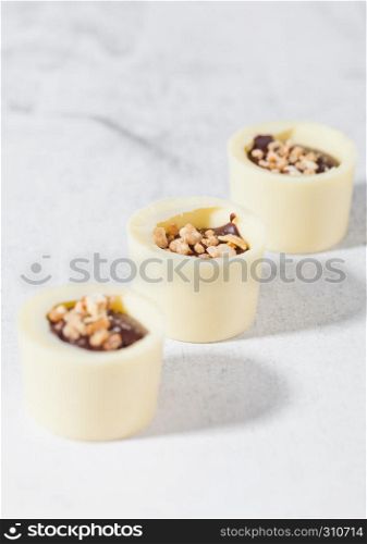 Assortment of luxury white chocolate candies variety on white background with hard shadows