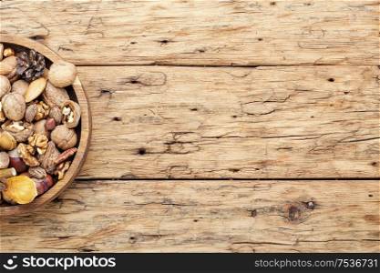 Assortment of nuts on wooden background.Top view with copy space.. Assortment of nuts