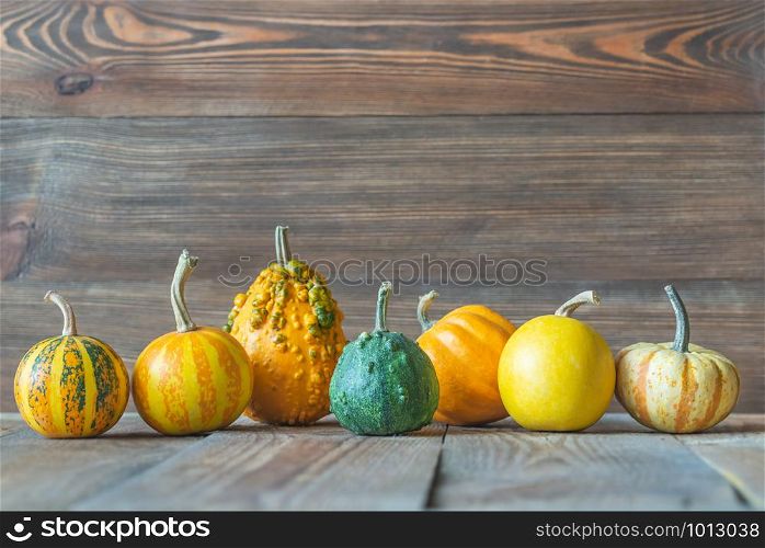 Assortment of ornamental pumpkins on the wooden background