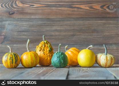 Assortment of ornamental pumpkins on the wooden background