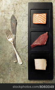 Assortment of raw fish on rustic background.