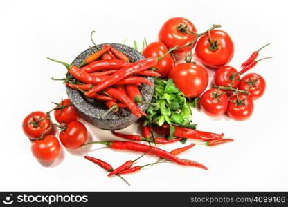 Assortment of red peppers and tomatoes on white background