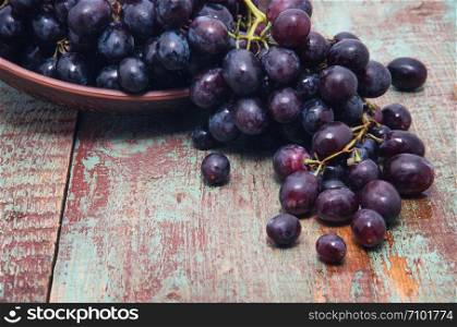 assortment of ripe sweet grapes in basket wooden background