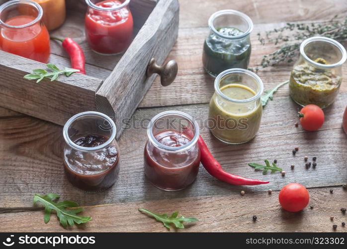 Assortment of sauces in the glass jars with ingredients