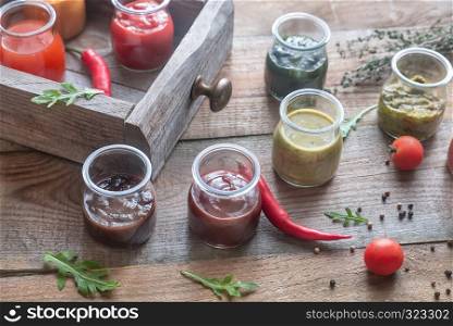 Assortment of sauces in the glass jars with ingredients