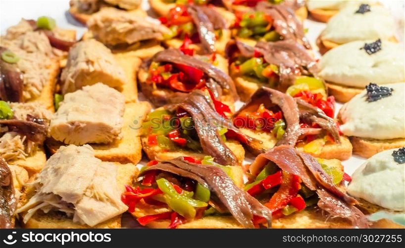 Assortment of Spanish tapas. Typical Spanish tapas in a bar, consisting of a snack or appetizer that is served with a drink