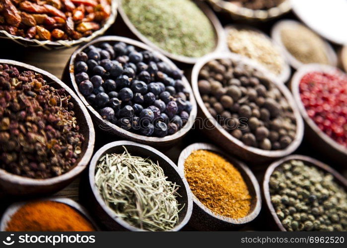 Assortment of spices in wooden bowl background