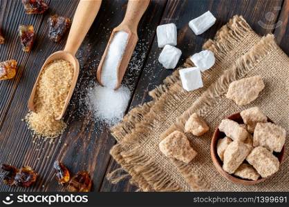 Assortment of sugar on wooden background