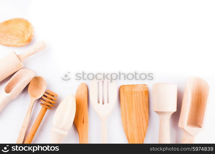 Assortment of wooden kitchen utensils on a white background with copy space. Wooden utensils