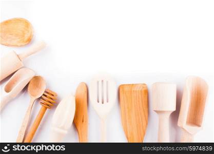 Assortment of wooden kitchen utensils on a white background with copy space. Wooden utensils