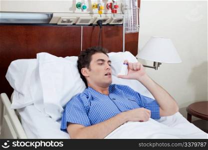 Asthmatic male patient on bed using asthma inhaler