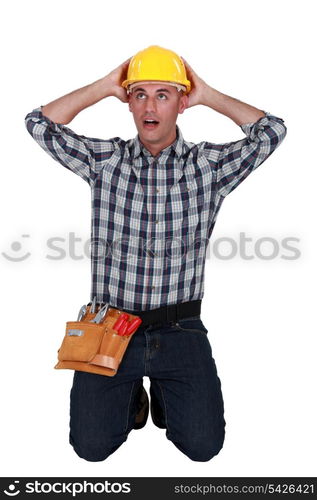 Astonished tradesman with his hands behind his head