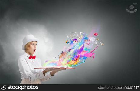 Astonished woman looking in book. Young woman in white hat with opened book in hands and splashes flying out