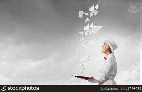 Astonished woman looking in book. Young woman in white hat with opened red book in hands