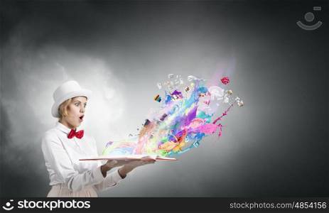 Astonished woman looking in book. Young woman in white hat with opened book in hands and splashes flying out