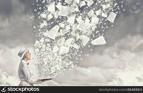 Astonished woman looking in book. Young woman in white hat with opened red book in hands