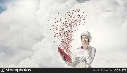 Astonished woman looking in book. Young woman in white hat with opened book in hands and characters flying out