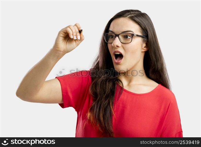 Astonished woman writing something on a glass board, isolated over white background