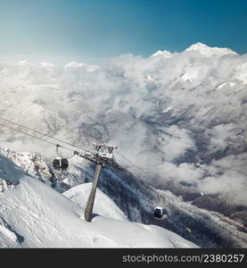 Astonishing view on Caucasus mountains from the Rosa Peak. Snowy mountains and low clouds. Sochi; Krasnaya Polyana (Rosa Khutor alpine ski resort); Western Caucasus; Russia.