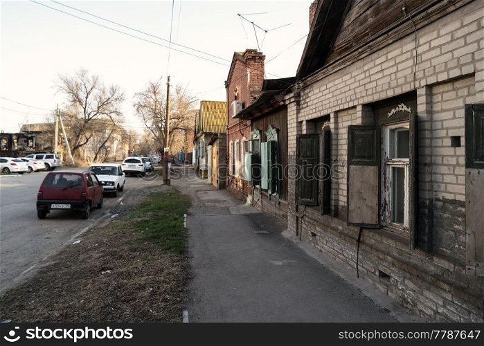 Astrakhan, Russia 12 of April 2018  In The Street Of Astrakhan In Sunny Spring Day With Expensive Cars Parked About Old Slum Houses. Astrakhan, Russia 12 of April 2018  In The Street Of Astrakhan In Sunny Spring Day With Cars Parked About Old Houses
