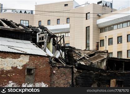 Astrakhan, Russia, 21 of March 2018  Charred Old Building In Front Of Modern Office.. Astrakhan, Russia, 21 of March 2018  Charred Old Building In Front Of Modern Office