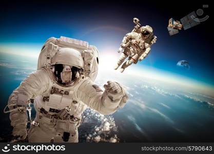 Astronaut in outer space against the backdrop of the planet earth. Elements of this image furnished by NASA.