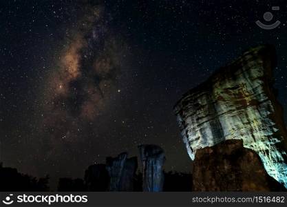 Astroscape at the night with rocks foreground