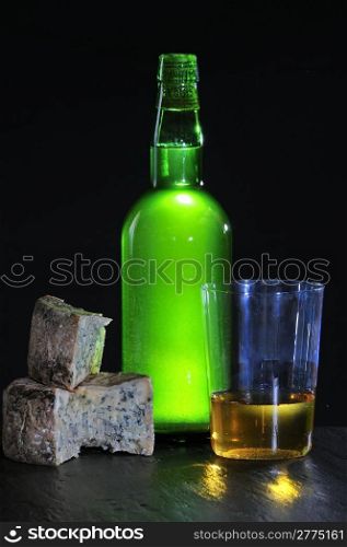 Asturian Cider and cabrales cheese with black background.