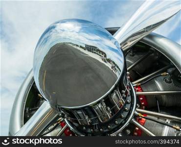 AT-6 Texan, known as the Harvard training plane engine with close up of reflection of runway and airfield in the nose of the propeller. Close up of propeller on American AT-6 Texan engine