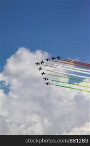 At Air Show, squadrons of aircraft emit colorful smoke